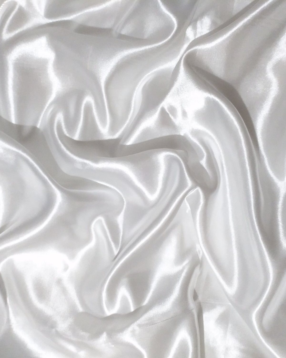 Primer plano de tejido de saten color perla con pliegues suaves
