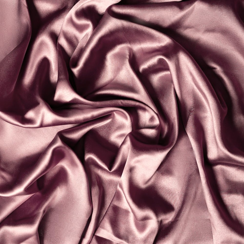 Primer plano de tejido de saten en tono rosa empolvado